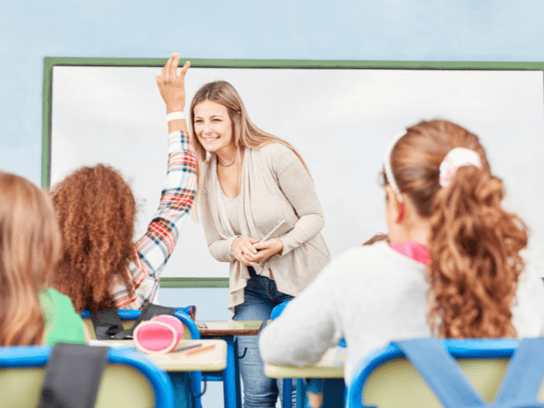 A teacher taking questions or answers from a class.