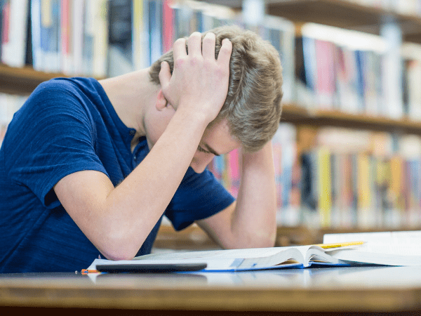 A teenager deep in learning cramming in the library.