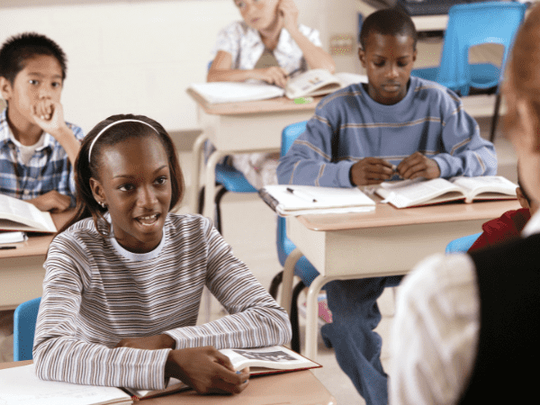 A classroom learning with a teacher at the front.