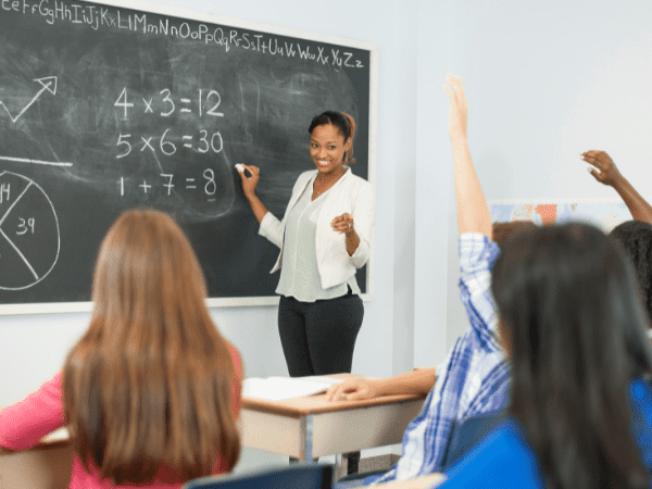 A teacher taking questions in a math class.