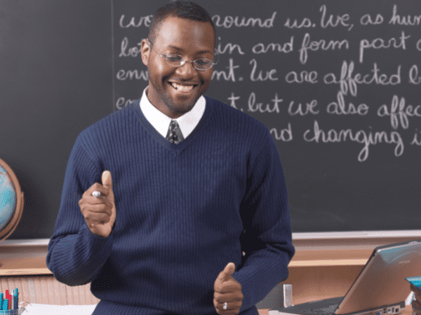 A teacher at the front of class enjoying teaching.