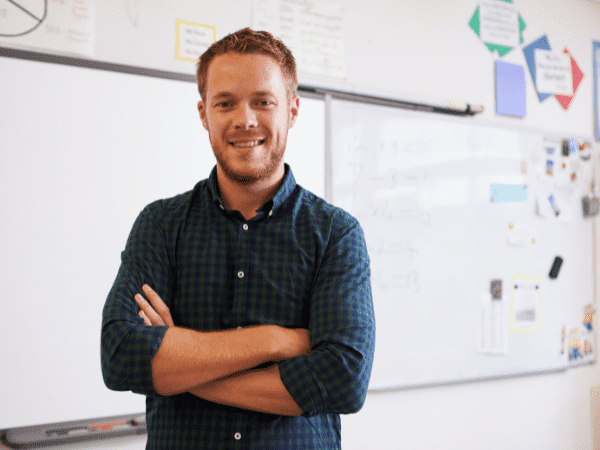 A teacher standing at the front of class. This Teacher Uses Google Classroom Apps